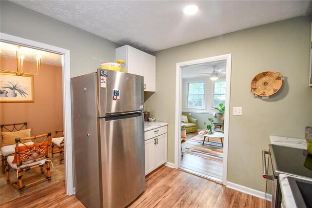 1235 Riverside Dr Unit H3, Gainesville, GA 30501 - kitchen featuring appliances with stainless steel finishes, light countertops, white cabinetry, and light wood-style flooring