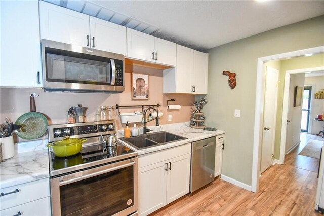 1235 Riverside Dr Unit H3, Gainesville, GA 30501 - kitchen with appliances with stainless steel finishes, light wood-style floors, white cabinets, and a sink