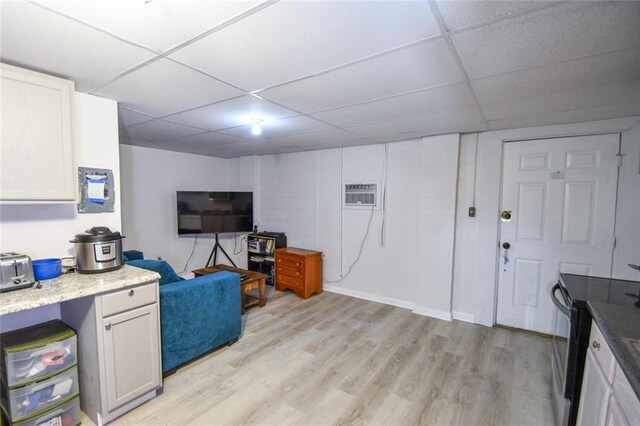 1235 Riverside Dr Unit H3, Gainesville, GA 30501 - living area with a drop ceiling, light wood-type flooring, concrete block wall, and a wall mounted air conditioner