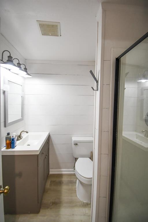 1235 Riverside Dr Unit H3, Gainesville, GA 30501 - bathroom with toilet, wood finished floors, vanity, visible vents, and a stall shower