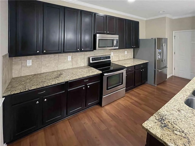 kitchen with light stone counters, stainless steel appliances, dark wood-style floors, and crown molding