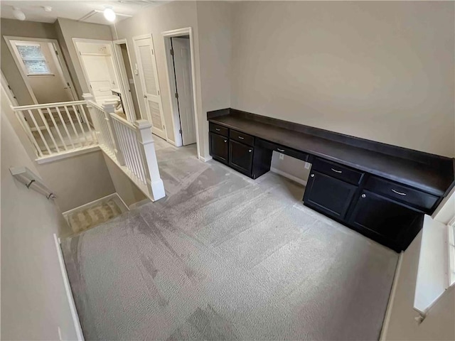 home office featuring light colored carpet and built in study area