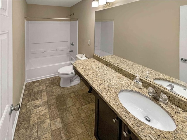 full bathroom with stone finish flooring, baseboards, shower / washtub combination, toilet, and vanity