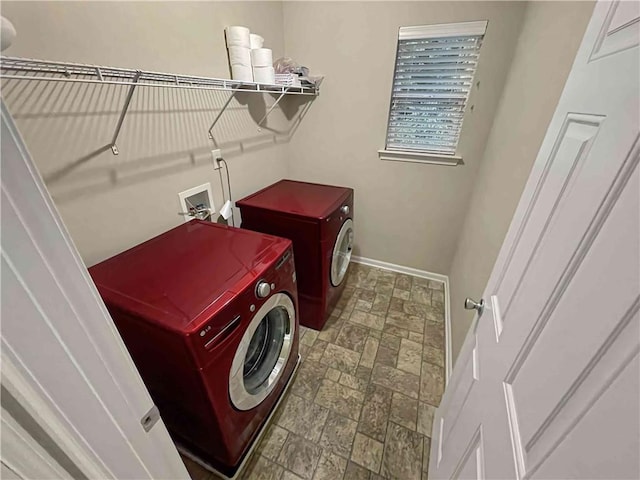 clothes washing area with laundry area, stone finish floor, baseboards, and separate washer and dryer