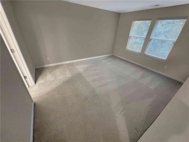 carpeted empty room featuring baseboards