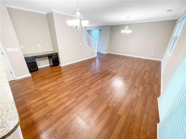 unfurnished living room with a notable chandelier, baseboards, light wood-type flooring, and ornamental molding