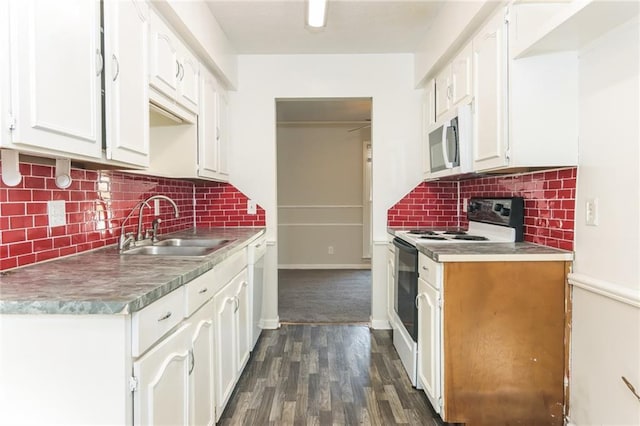 kitchen with white appliances, decorative backsplash, a sink, and white cabinets