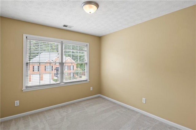 unfurnished room with a textured ceiling and light colored carpet