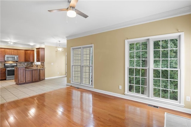 unfurnished living room with ceiling fan, light hardwood / wood-style flooring, crown molding, and sink