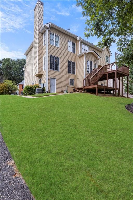 back of house with a lawn and a deck