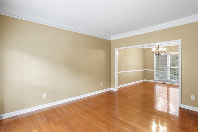 unfurnished room with hardwood / wood-style flooring, crown molding, and a chandelier