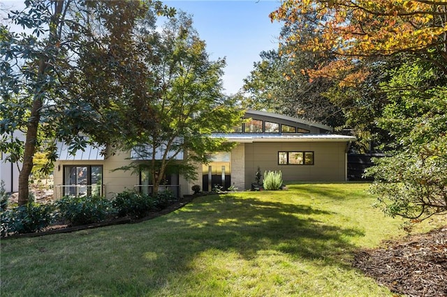 rear view of property featuring a yard