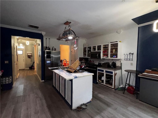 4018 Carisbrook Dr, Union City, GA 30291 - kitchen with black fridge, dark wood-style flooring, a kitchen island with sink, light countertops, and crown molding