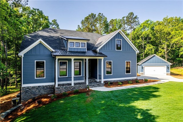 view of front of home featuring board and batten siding, an outdoor structure, covered porch, a garage, and a front lawn