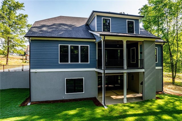 rear view of property with a patio, roof with shingles, and a sunroom