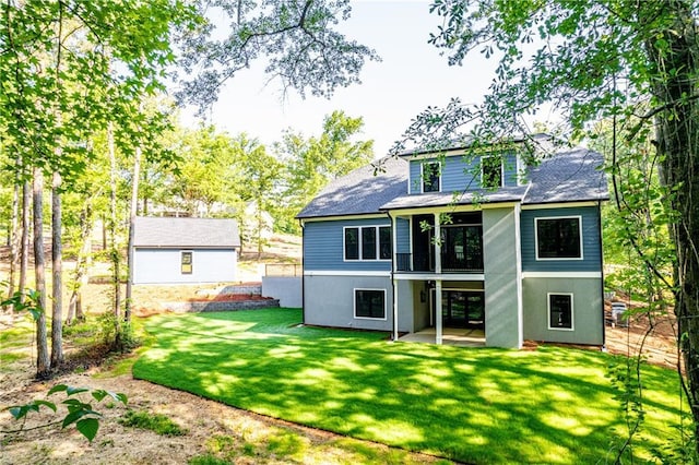 rear view of house with a sunroom, a patio area, a lawn, and a shingled roof