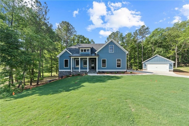 view of front of property with a garage, an outbuilding, covered porch, a front yard, and board and batten siding