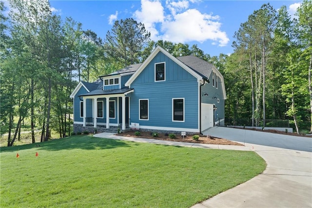 view of front of property featuring driveway, board and batten siding, a front yard, and a garage