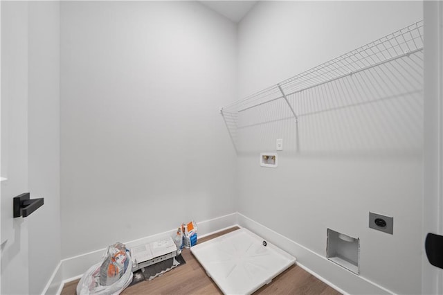 washroom with hookup for a washing machine, hookup for an electric dryer, wood finished floors, and baseboards