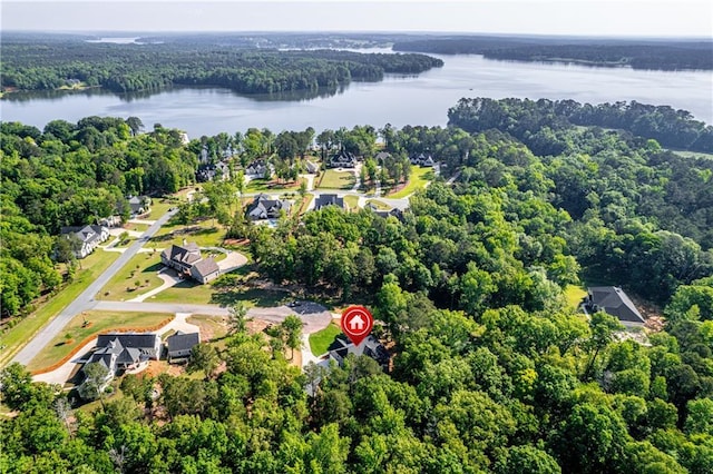 aerial overview of property's location featuring a large body of water and a heavily wooded area
