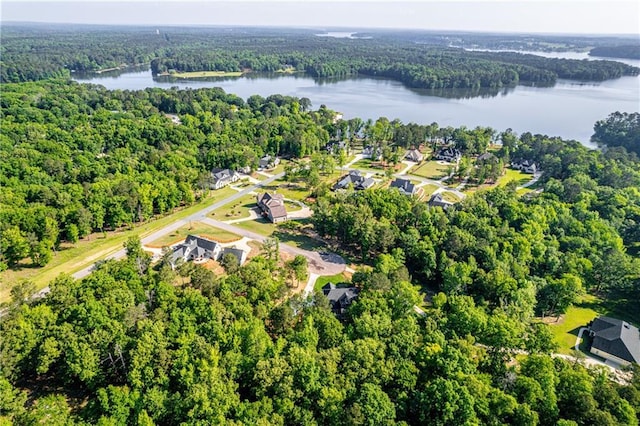 drone / aerial view of a heavily wooded area and a large body of water