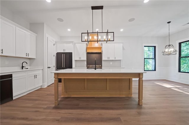 kitchen with a sink, black appliances, light countertops, white cabinets, and dark wood-type flooring