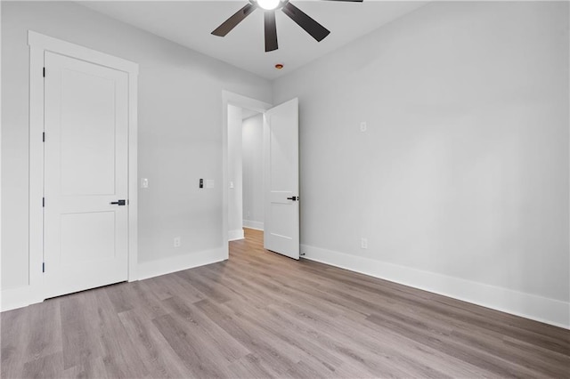 unfurnished bedroom featuring wood finished floors, baseboards, and ceiling fan