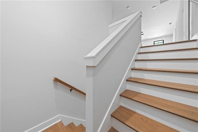 stairway featuring baseboards and wood finished floors