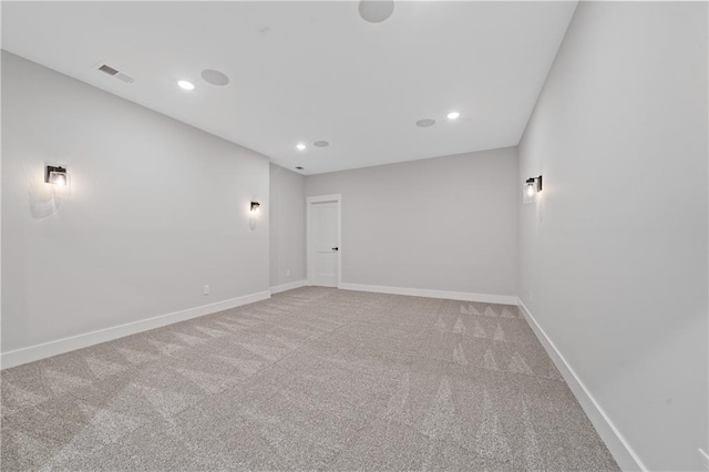 spare room featuring carpet, recessed lighting, and baseboards