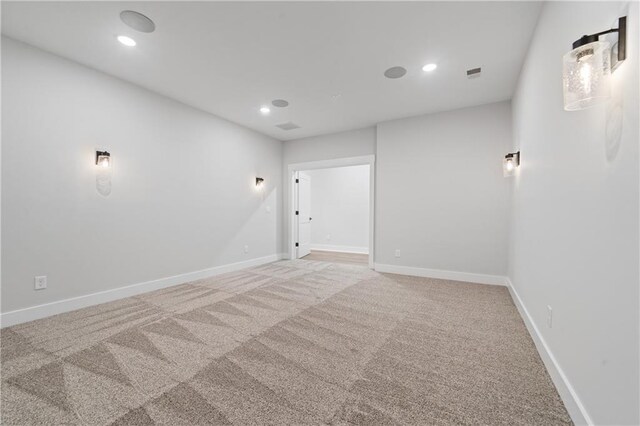 empty room with light carpet, recessed lighting, and baseboards