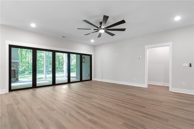 unfurnished room with light wood finished floors, a ceiling fan, baseboards, and recessed lighting