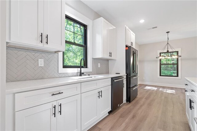 kitchen featuring stainless steel dishwasher, high quality fridge, a sink, white cabinetry, and recessed lighting