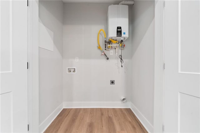 washroom featuring tankless water heater, electric dryer hookup, light wood-style floors, hookup for a washing machine, and baseboards