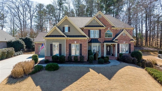 craftsman-style house featuring driveway and brick siding