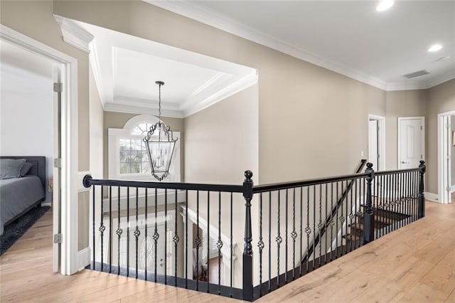 hallway featuring ornamental molding, an upstairs landing, and wood finished floors