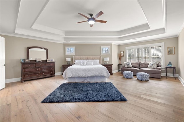 bedroom featuring baseboards, a raised ceiling, hardwood / wood-style flooring, and crown molding