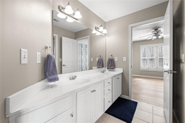 bathroom with a sink, double vanity, tile patterned flooring, and a ceiling fan