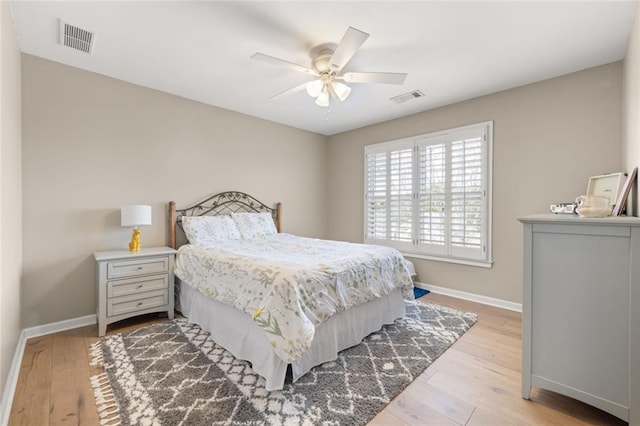 bedroom with light wood-type flooring, baseboards, visible vents, and a ceiling fan