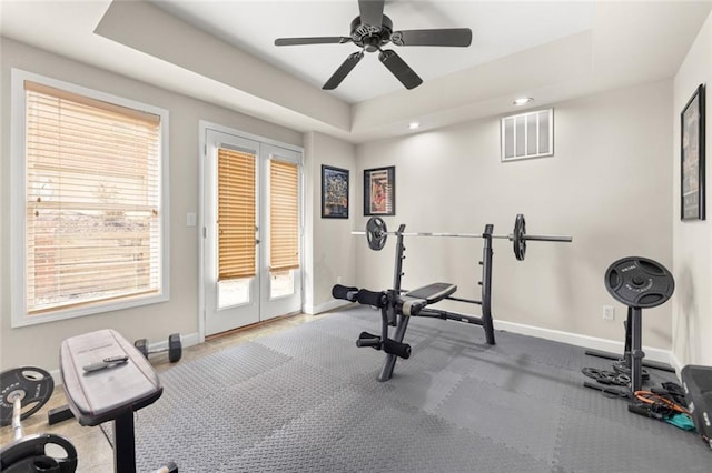 exercise room with baseboards, visible vents, a tray ceiling, and recessed lighting