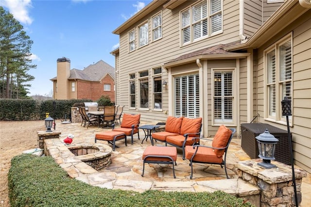 view of patio / terrace featuring outdoor dining space, an outdoor living space with a fire pit, and fence