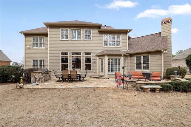 back of property featuring a patio area, a chimney, an outdoor living space, and area for grilling