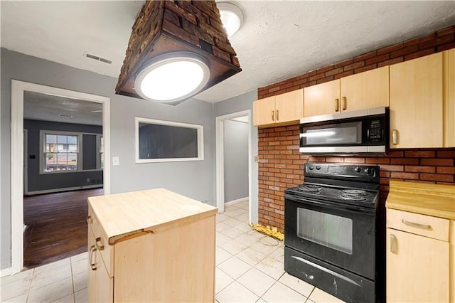 kitchen featuring wood counters, light brown cabinetry, a textured ceiling, light tile patterned floors, and electric range