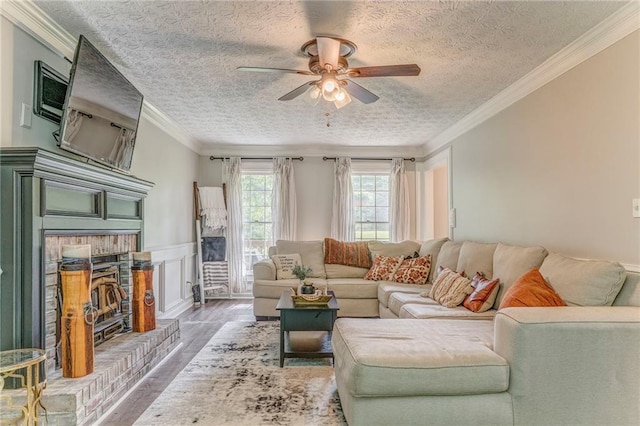 323 Schoolhouse Rd, Rockmart, GA 30153 - living room featuring wood finished floors, ceiling fan, a fireplace, crown molding, and a textured ceiling