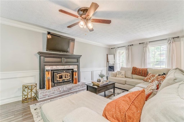 323 Schoolhouse Rd, Rockmart, GA 30153 - living area featuring a textured ceiling, wood finished floors, ornamental molding, a decorative wall, and a ceiling fan