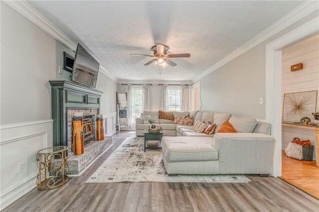 323 Schoolhouse Rd, Rockmart, GA 30153 - living room with a ceiling fan, wood finished floors, a fireplace, a textured ceiling, and crown molding