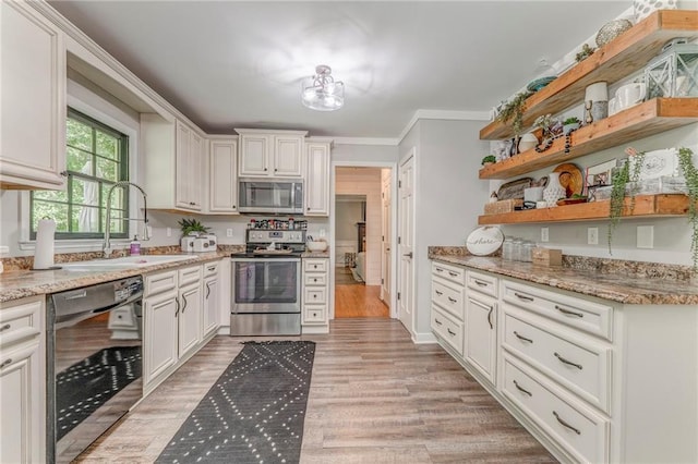 323 Schoolhouse Rd, Rockmart, GA 30153 - kitchen with appliances with stainless steel finishes, open shelves, light wood-style floors, white cabinets, and light stone counters