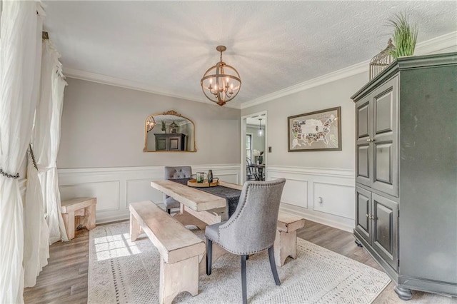323 Schoolhouse Rd, Rockmart, GA 30153 - dining room with a chandelier, light wood-type flooring, wainscoting, and crown molding