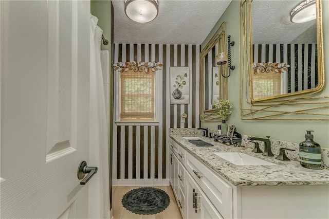323 Schoolhouse Rd, Rockmart, GA 30153 - bathroom featuring wallpapered walls, double vanity, and a textured ceiling