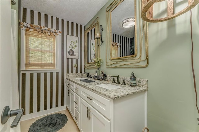 323 Schoolhouse Rd, Rockmart, GA 30153 - bathroom with wallpapered walls, double vanity, and a textured ceiling