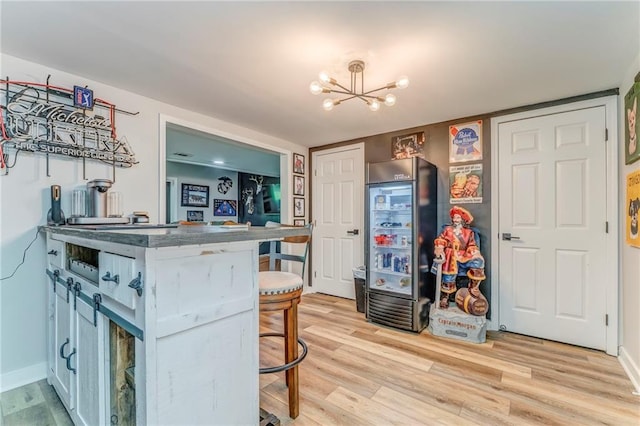 323 Schoolhouse Rd, Rockmart, GA 30153 - kitchen featuring a chandelier, a breakfast bar area, light wood finished floors, and fridge